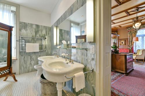 沙夫豪森公园别墅酒店的白色的浴室设有水槽和淋浴。