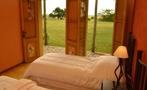 GuichónAlquimia Posada的一间卧室设有两张床和开放式窗户。