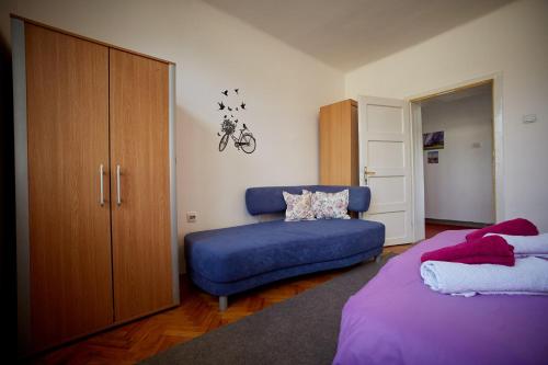 图兹拉Central Tuzla apt - free parking的一间卧室配有一张床和一张蓝色的沙发