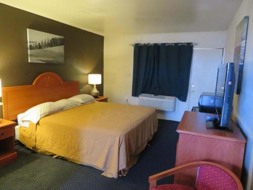 瓦列霍Carquinez Inn的配有一张床和一台平面电视的酒店客房