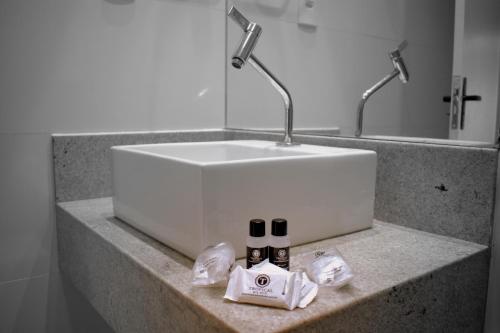 阿拉卡茹Tropical Mar Hotel的浴室柜台配有水槽和2瓶肥皂