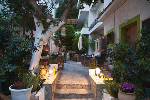 圣加利尼吉奥马酒店的户外庭院配有桌椅和植物。