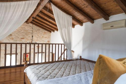 AnafonítriaVilla Margarita的一间带一张床的卧室,位于带木制天花板的房间内
