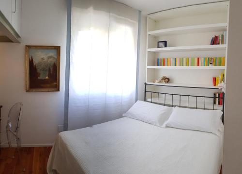 加尔达湖滨Riva Celeste的一间卧室设有床铺和窗户,备有书籍
