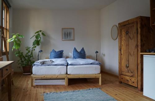 格赖茨Pension zum Hirschstein的一间卧室配有一张带蓝色枕头的床。