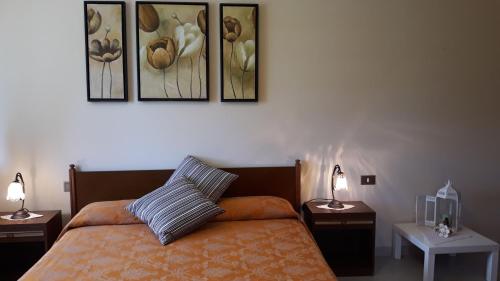 Torricella PelignaAgriturismo Persichitti的卧室配有一张墙上三幅照片的床