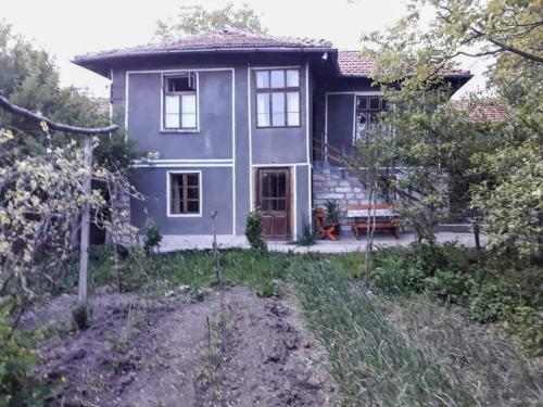 Gorsko SlivovoBeeFree的一座紫色的房子,前面设有长凳