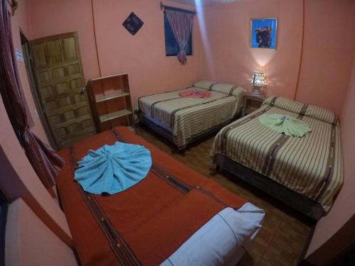 帕纳哈切尔Hotel Encuentro del Viajero的一间客房内配有两张床的房间