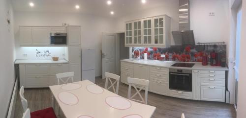 武尔岑zentral gelegene top ausgestattete Wohnung的厨房配有白色橱柜和桌椅
