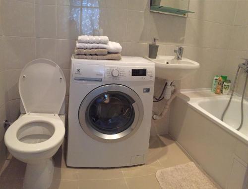 敖德萨Charming apartment的一间带洗衣机、卫生间和水槽的浴室
