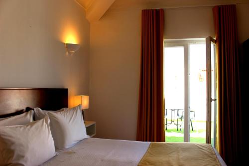 米尔芳提斯城Guest House - Duna Parque Group的酒店客房,设有床和滑动玻璃门