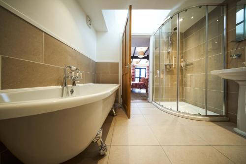 斯特灵Thornhill Lodge, Historic 4 Bed, 4 Ensuite的设有带浴缸和淋浴的浴室。