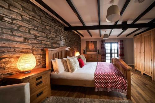 斯特灵Thornhill Lodge, Historic 4 Bed, 4 Ensuite的一间卧室设有一张床和石墙