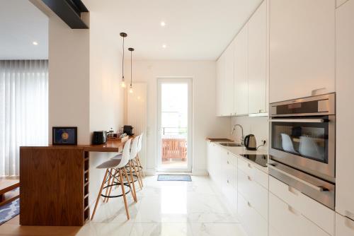 卢森堡CityStudios的厨房配有白色橱柜和木台面