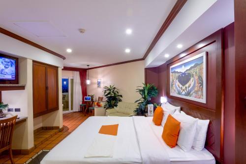 卡伦海滩Pacific Club Resort的卧室配有带橙色枕头的大型白色床