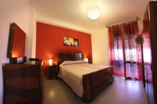 恩波利拉特拉扎住宿加早餐旅馆的一间卧室设有一张床和红色的墙壁