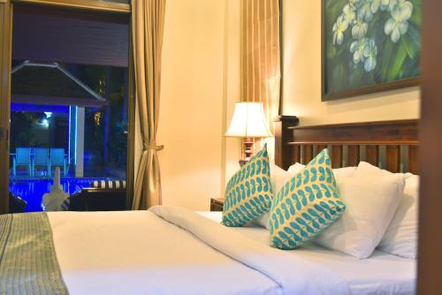 乔木提恩海滩4 Bed Villa Private Pool and BBQ Jomtien Beach的一间卧室配有一张带蓝色和白色枕头的床