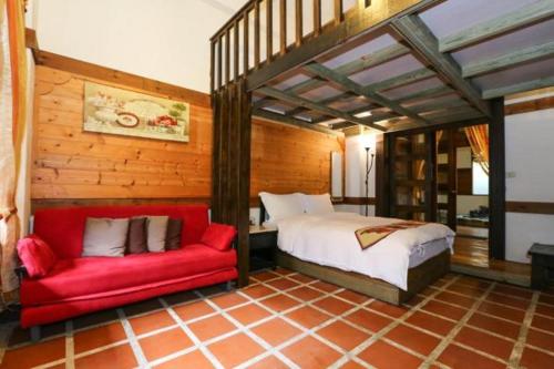 玉里镇纽澳华山庄的一间卧室配有一张床和一张红色的沙发