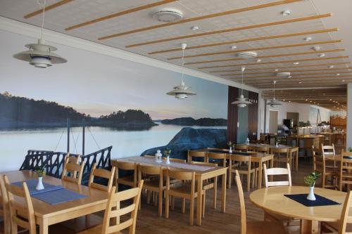 卢恩斯基尔阿斯迪福空赋格酒店的餐厅设有木桌和椅子以及大型壁画