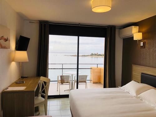 萨尔泰纳Hôtel du Golfe的配有一张床、一张书桌和一扇窗户的酒店客房