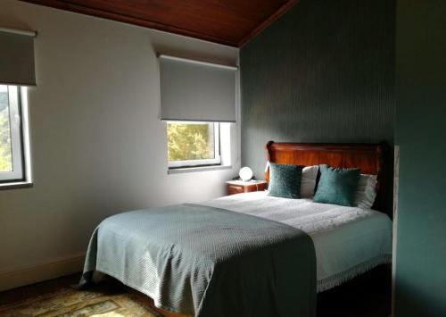 拜昂冬宫农场 - 庄园酒店的一间卧室配有一张带蓝色床单的床和两个窗户。