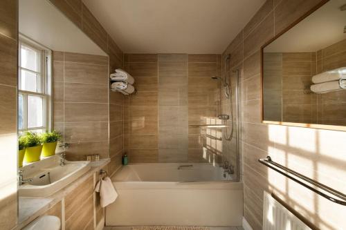 斯特灵Thornhill House - Historic 5 Bedroom 5 Ensuite的带浴缸和盥洗盆的浴室