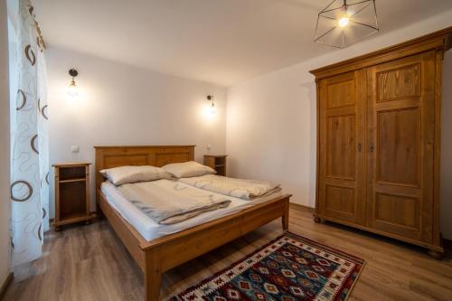 锡吉什瓦拉Gloria Apartments的一间卧室配有一张床和一个木制橱柜