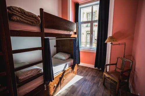 里斯本里斯本家庭旅馆的客房设有双层床、窗户和椅子。