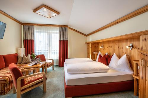 上陶恩Hotel Garni Haus Tyrol的酒店客房,设有两张床和一张沙发
