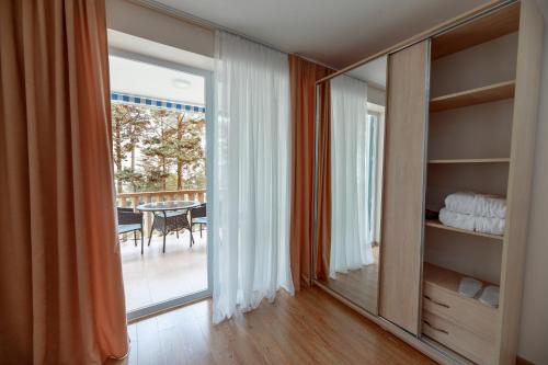乌雷基Kolkhida Resort & Spa的客房设有滑动玻璃门,可通往庭院。