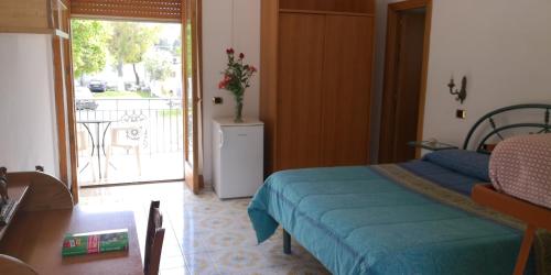 庞贝Villaggio "Camping Pompei"的一间卧室设有一张床,并有通往阳台的门