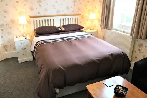 米尔顿凯恩斯Telford House的一间卧室配有床、两个床头柜和一张桌子