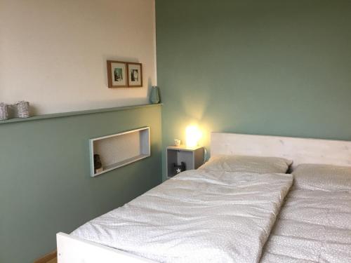 多斯滕Wohlfühlambiente in Dorsten的卧室配有白色的床和绿色的墙壁