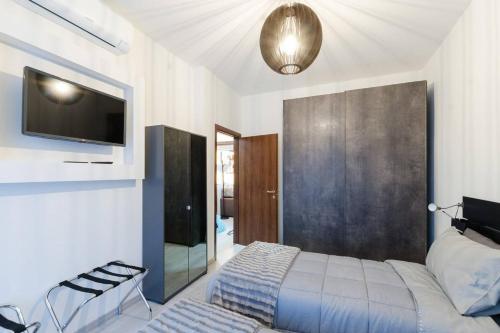 米兰Appartamento moderno San Siro的一间卧室配有一张床,墙上配有电视
