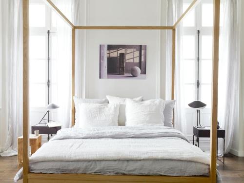 瓦讷Une Suite A Vannes的白色卧室配有带白色枕头的天蓬床
