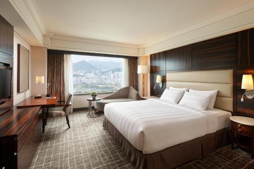 釜山釜山乐天酒店的配有一张床、一张书桌和一扇窗户的酒店客房