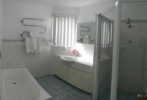 科莱特柯莱特隐居公寓的一间带水槽、浴缸和淋浴的浴室
