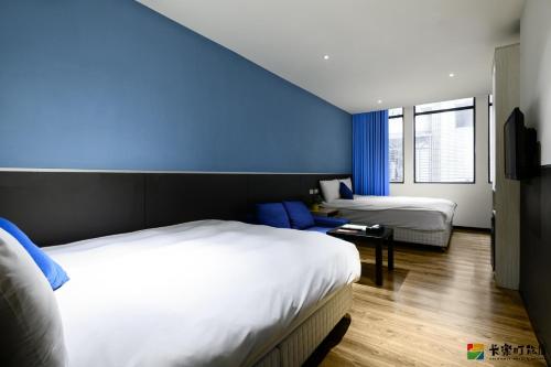 台北卡乐町旅店 的一间卧室设有两张床和蓝色的墙壁
