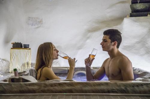 罗克布吕讷-卡普马丹Monaco's Cottage & Spa的男人和女人在浴缸里喝葡萄酒