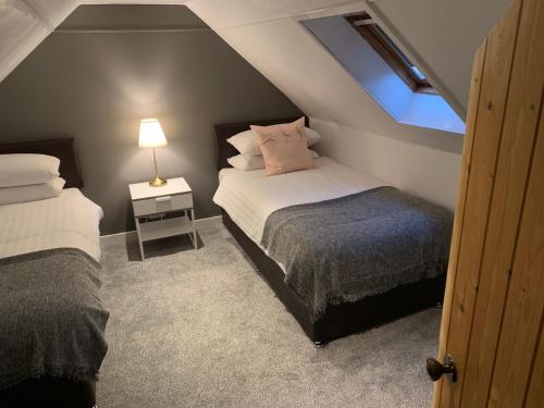 波特里Heatherland Cottage的阁楼卧室设有两张床和窗户。