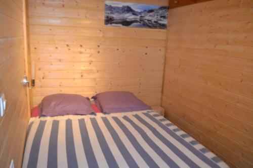 Saint-Julien-en-ChampsaurPetit appartement en montagne的小房间,木墙里设有一张床
