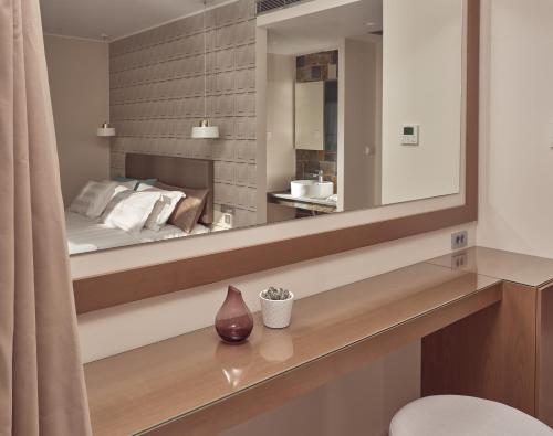卡拉马孔Golden Sun Resort - Adults Only的一间带大镜子和床的卧室