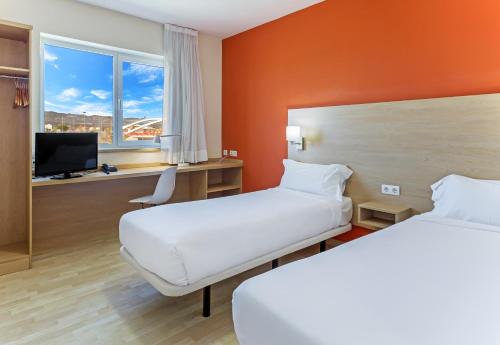 拉斯·罗萨斯·德·马德里B&B HOTEL Madrid Las Rozas的酒店客房设有两张床和电视。