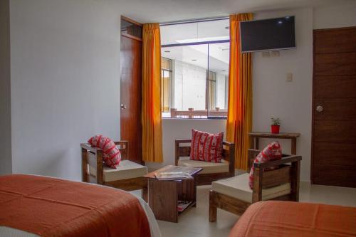 奇瓦伊Pandora hotel colca的一间卧室配有一张床、椅子和电视