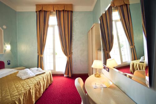 切塞纳蒂科切塞纳蒂科大酒店的客房设有床、桌子和镜子