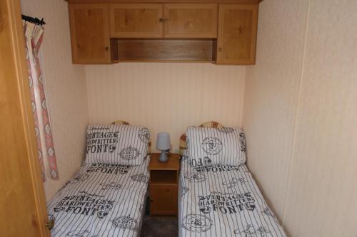文戈热沃Domek na półwyspie Kal的小型客房配有两张单人床和橱柜。