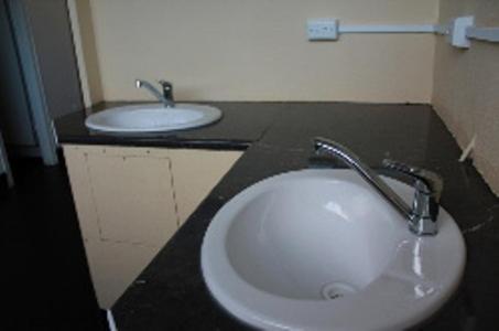 德文港德文波特亚伯塔斯曼小屋酒店的浴室设有两个盥洗盆和黑色的台面