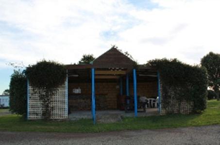 德文港德文波特亚伯塔斯曼小屋酒店的草上用蓝色的杆子建造的砖砌小建筑