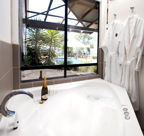 奥古斯塔港雄伟绿洲公寓的一间带白色水槽和窗户的浴室