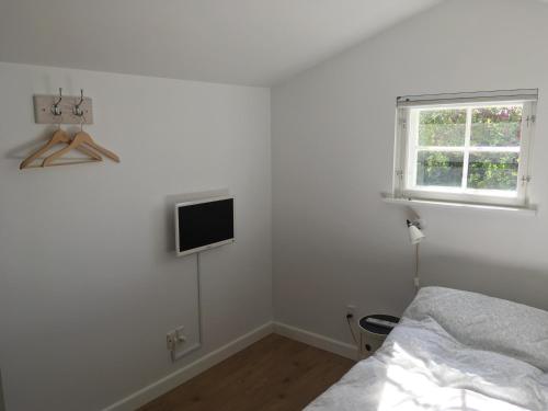 吉利勒杰Cozy Guesthouse的卧室配有一张床,墙上配有电视。